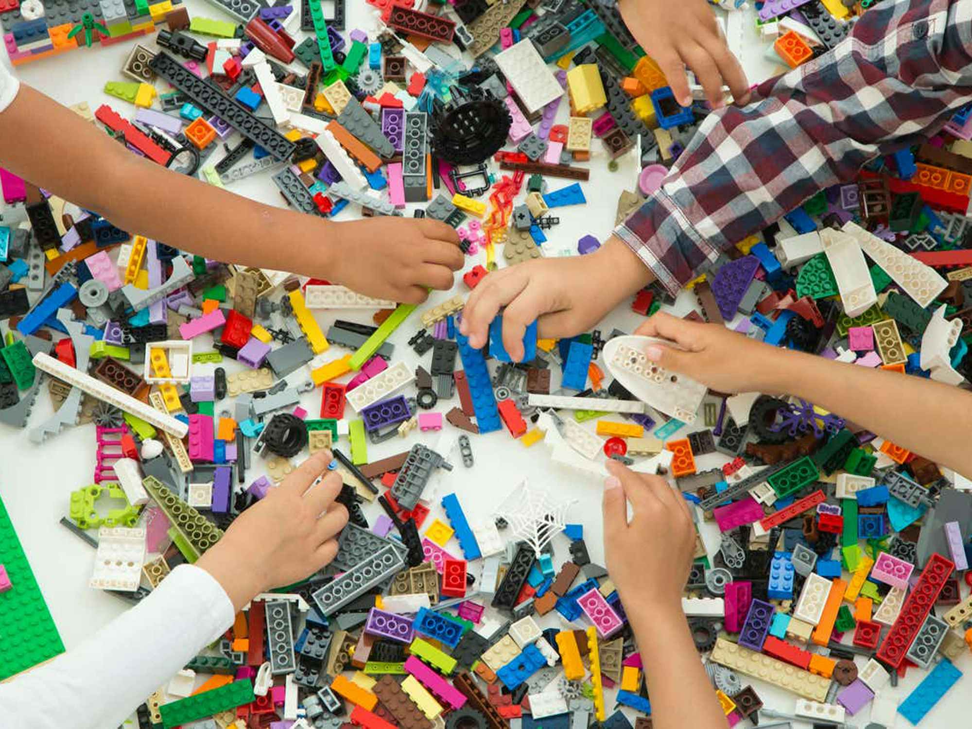 children reaching in a pile of legos