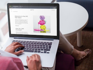 Someone looking at the webpage about the OPI Test Salon on a laptop