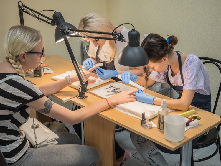 Beauty school students practicing nail services 
