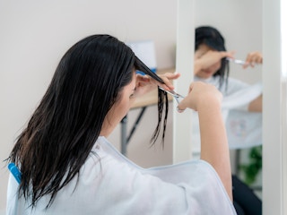 Someone cutting their own hair at home