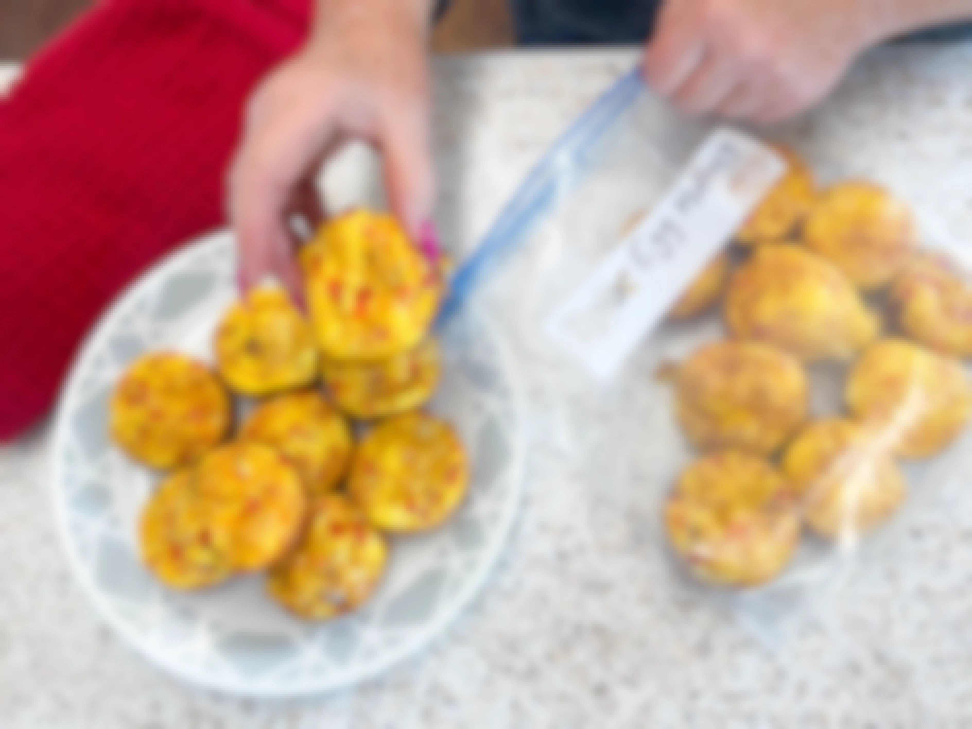 a person putting a plate of egg muffins into a freezer bag 