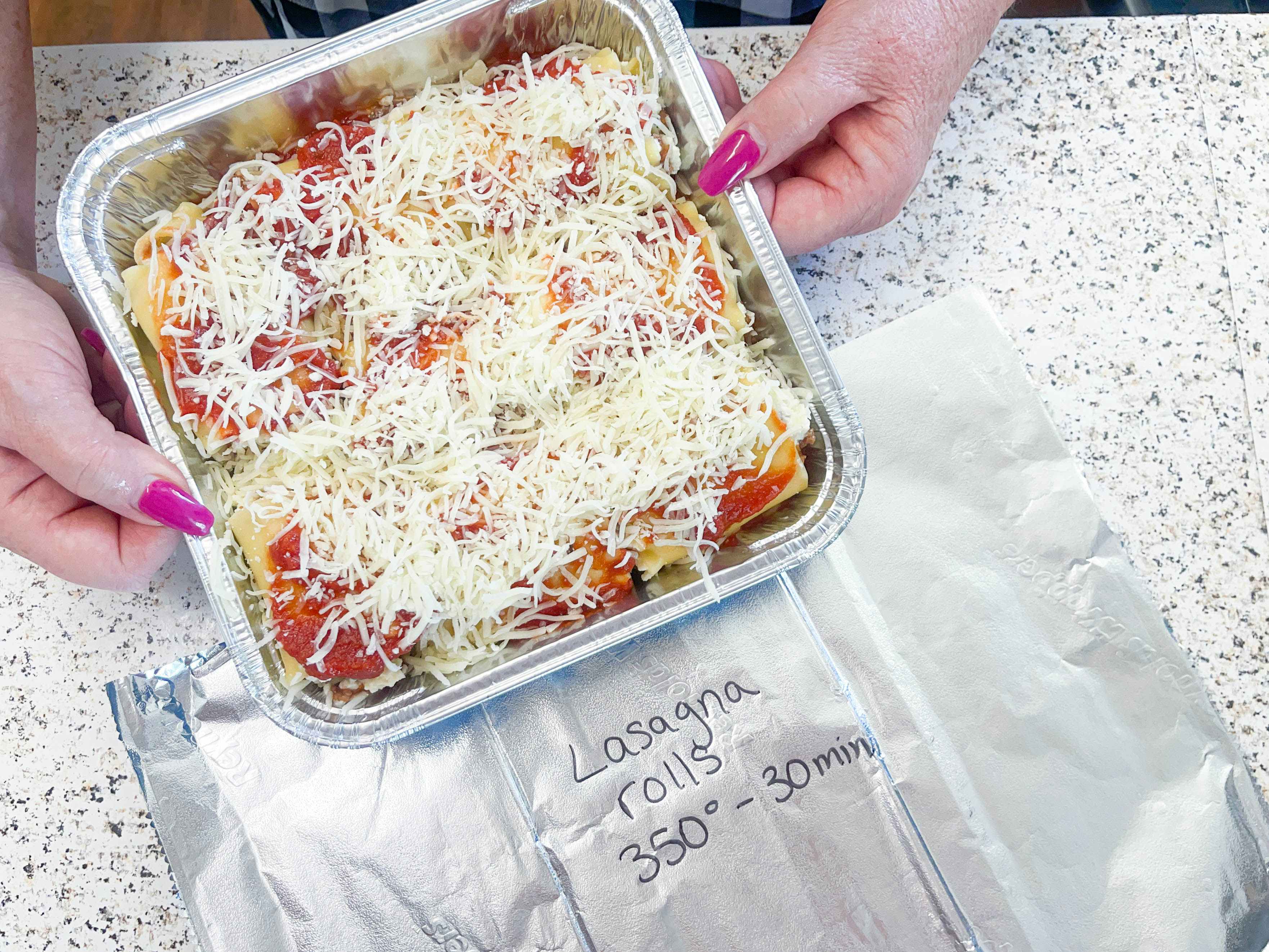 a person holding a lasagna rollup freezer meal