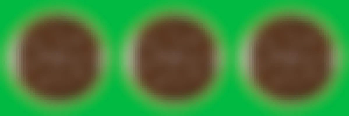 Three Girl Scout Thin Mints cookies on a green background
