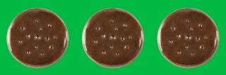 Three Girl Scout Thin Mints cookies on a green background