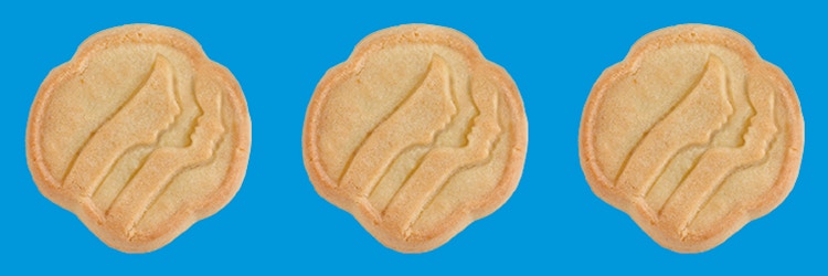 Three Girl Scout Trefoils cookies on a blue background