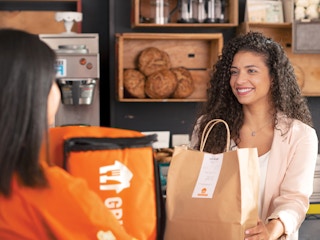 a grubhub driver picking up an order from a restaurant