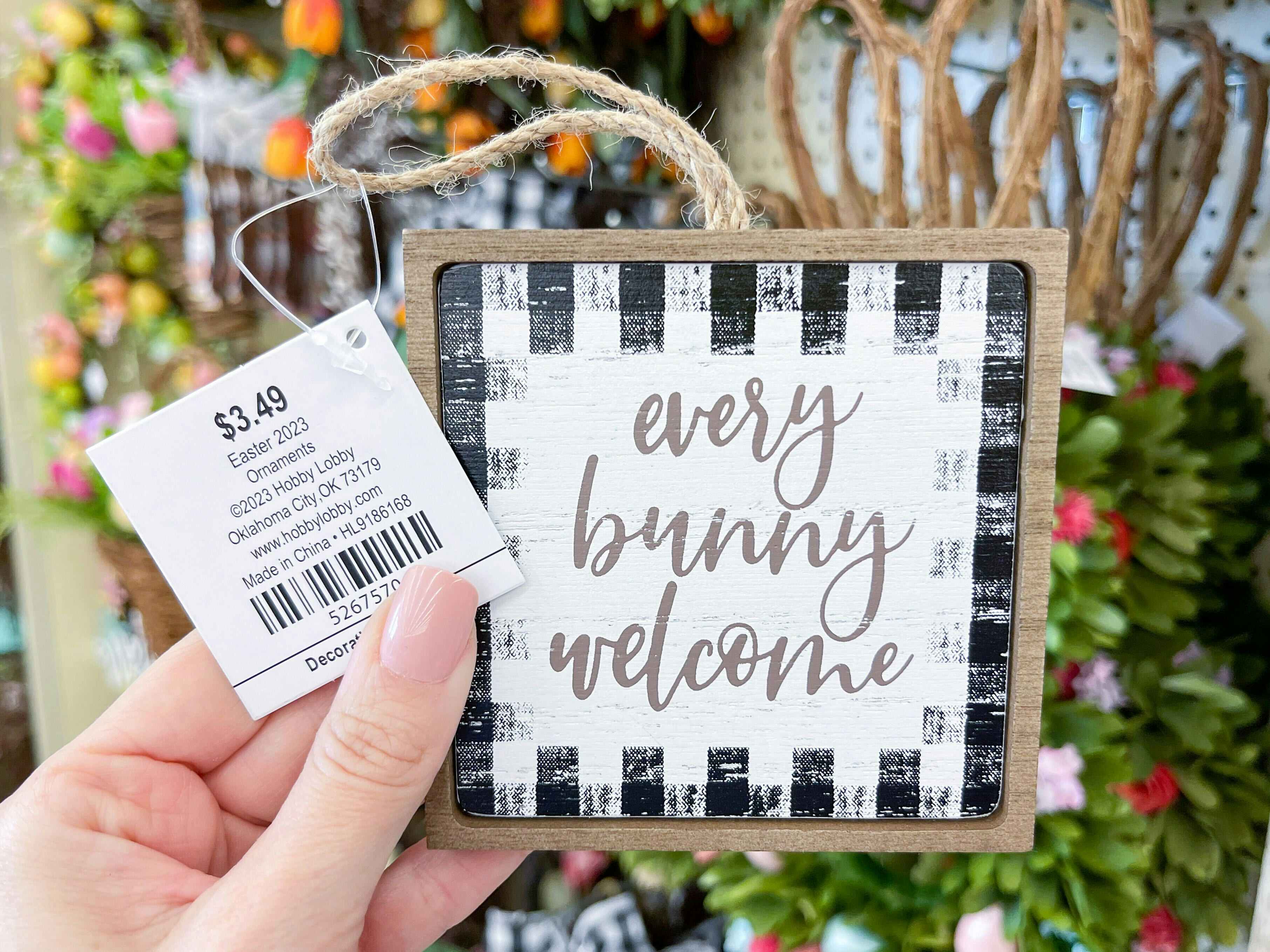 Hand holding a Sign that reads, " Every bunny welcome" at Hobby Lobby