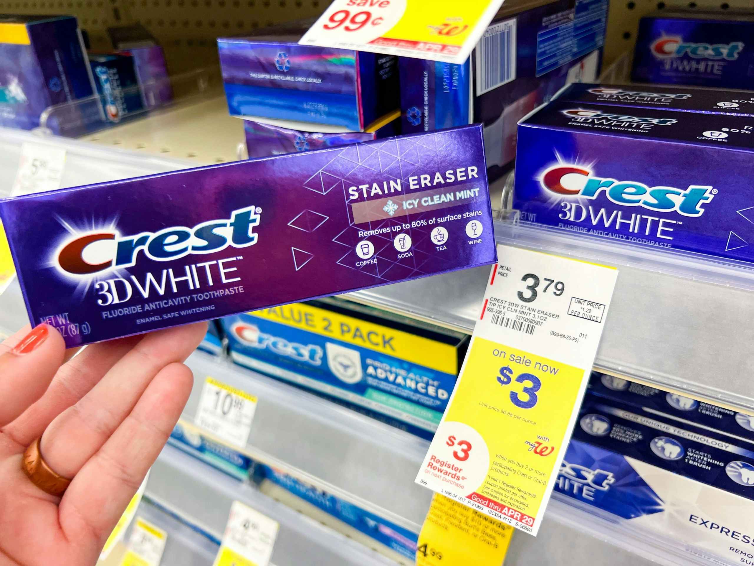 hand holding crest toothpaste next to sales tag