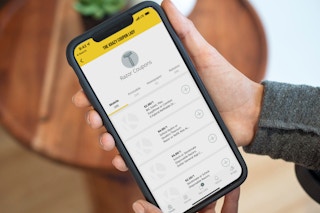 a person holding a cellphone with the Krazy Coupon Lady app on screen