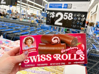 a person holding little debbie strawberry swiss rolls in walmart