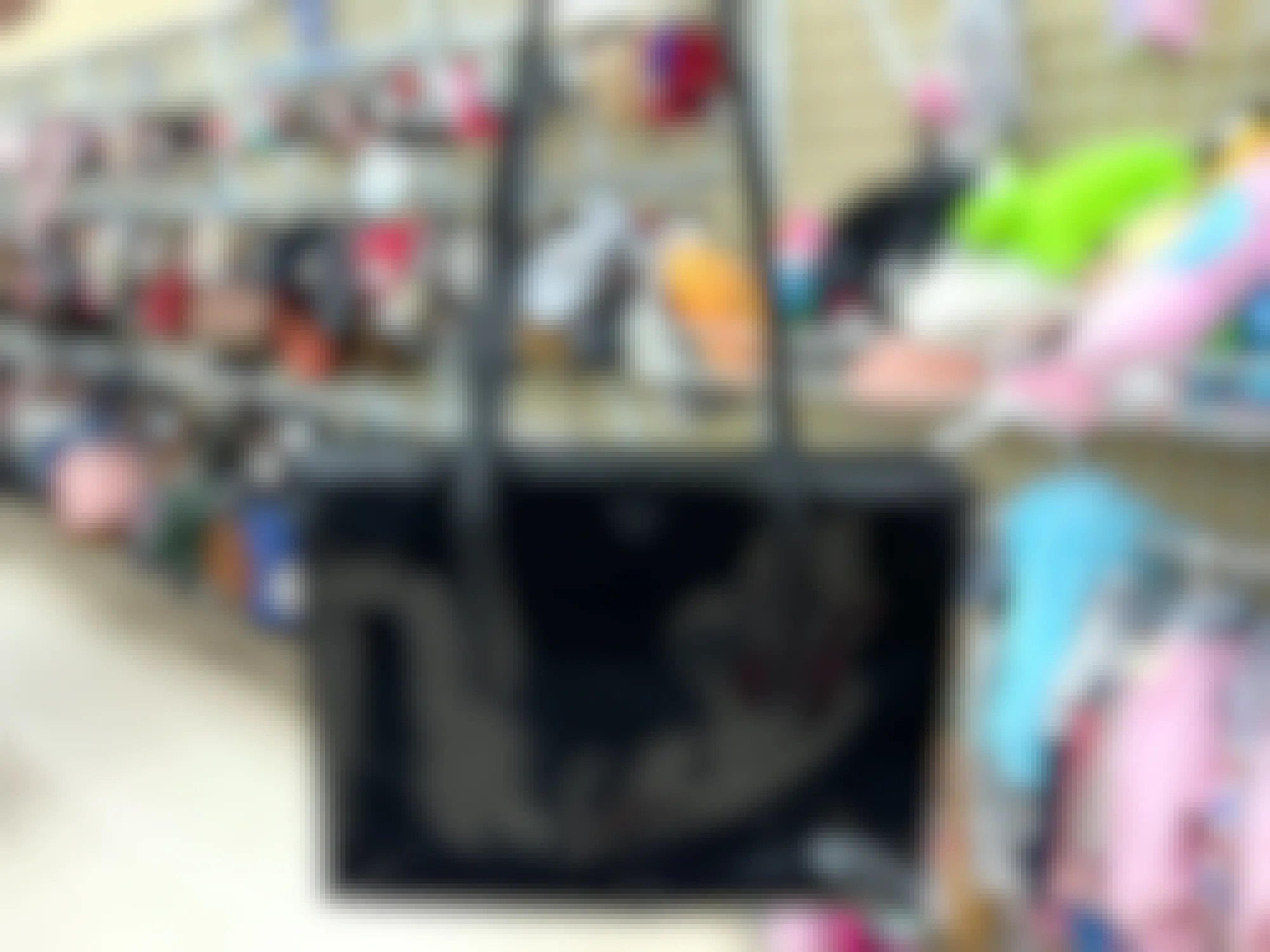 person holding a black prada tote at a thrift store