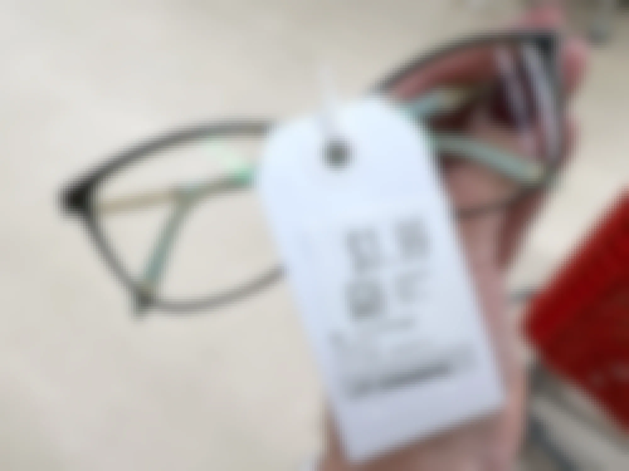 person holding a pair of tiffany reading glasses at a thrift store