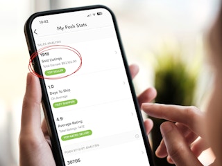 person looking at a screenshot of their posh stats and sold listings on a phone