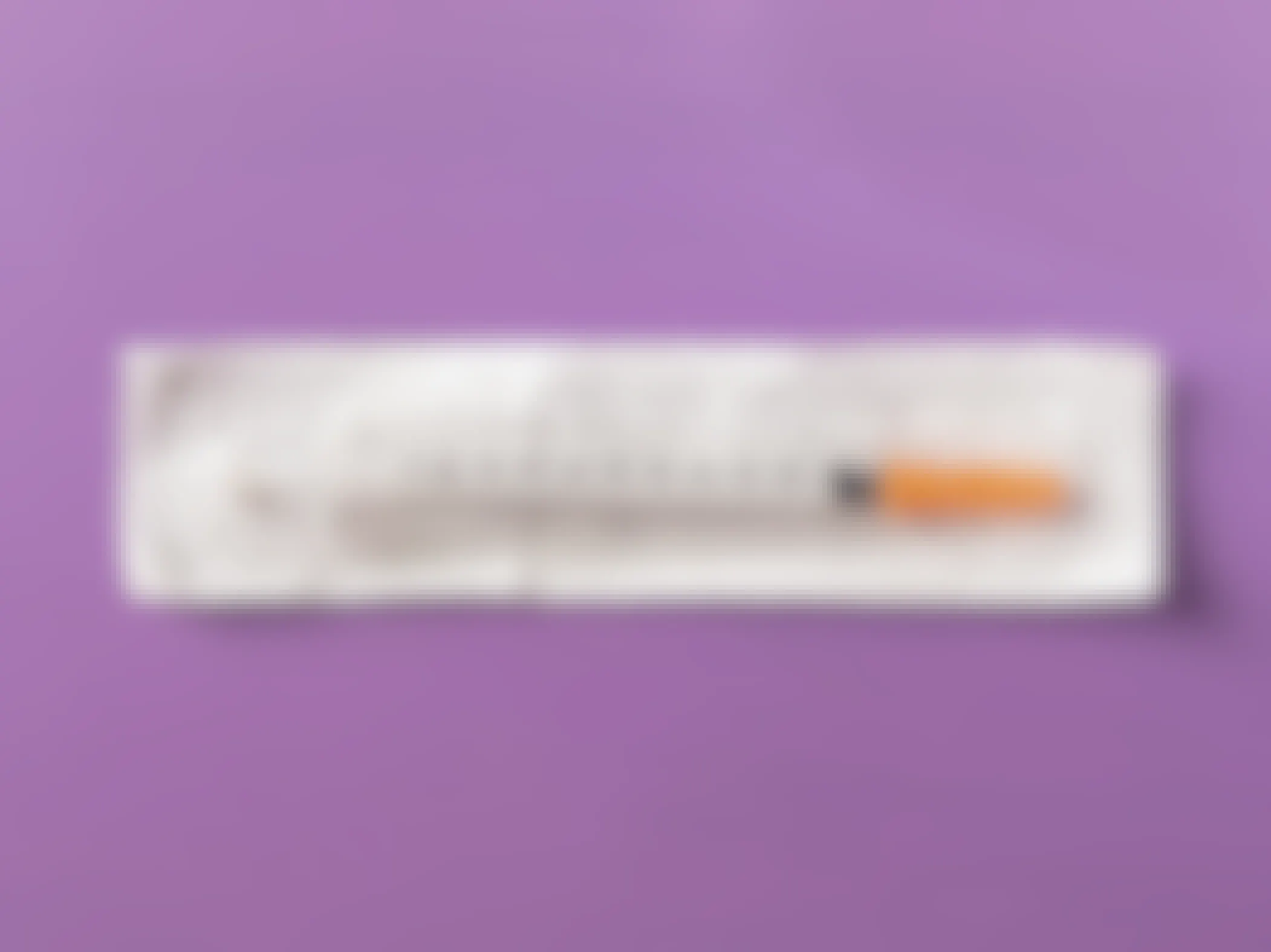 disposable plastic insulin syringe with needle in package on violet background