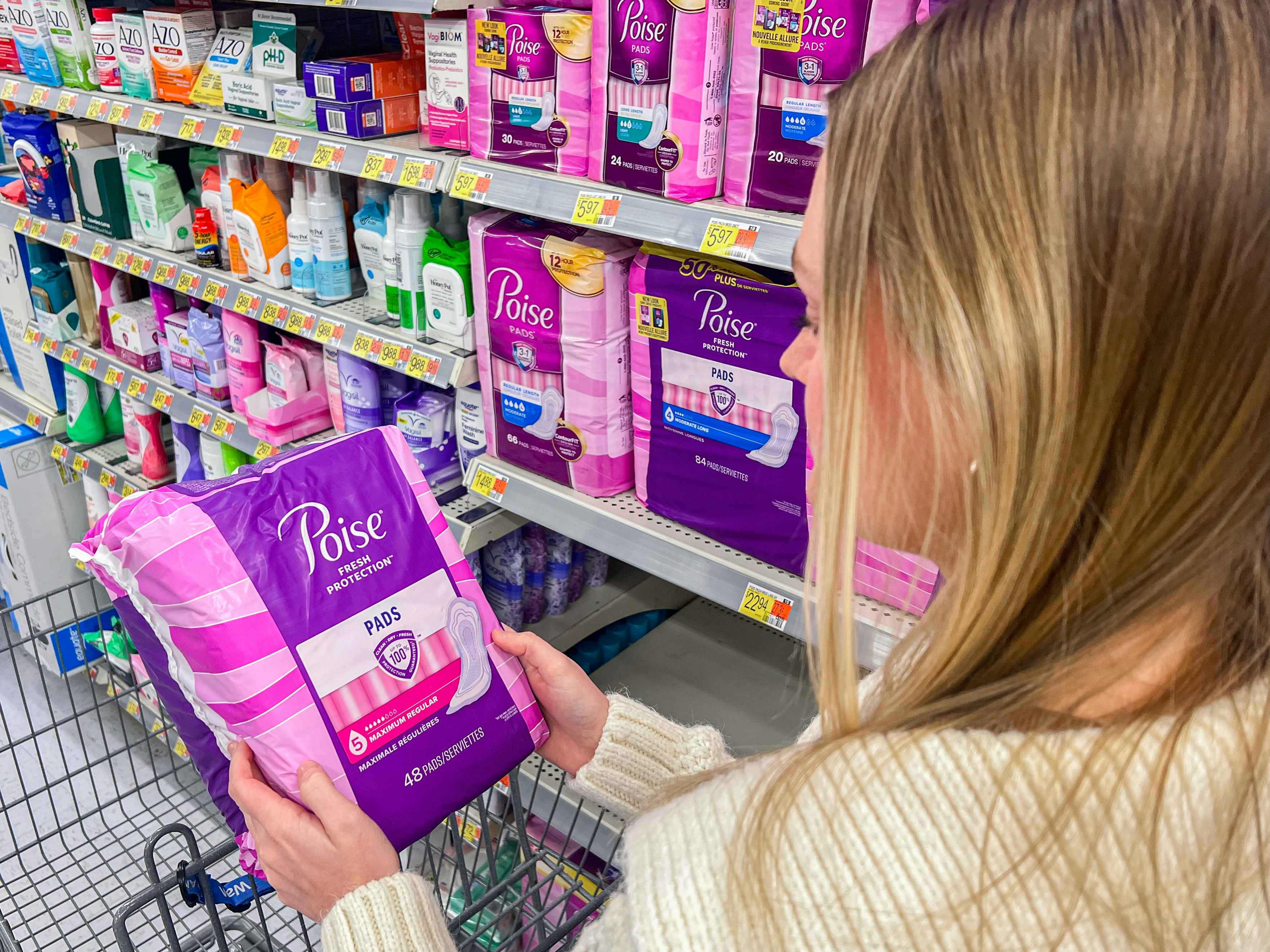 a person looking at poise pads in walmart