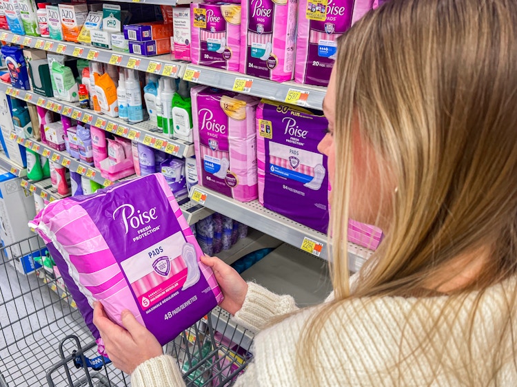 a person looking at poise pads in walmart