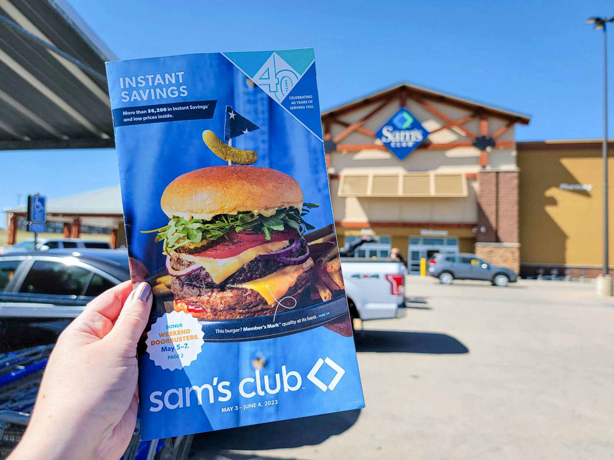 hand holding an instant savings book in front of sam's club