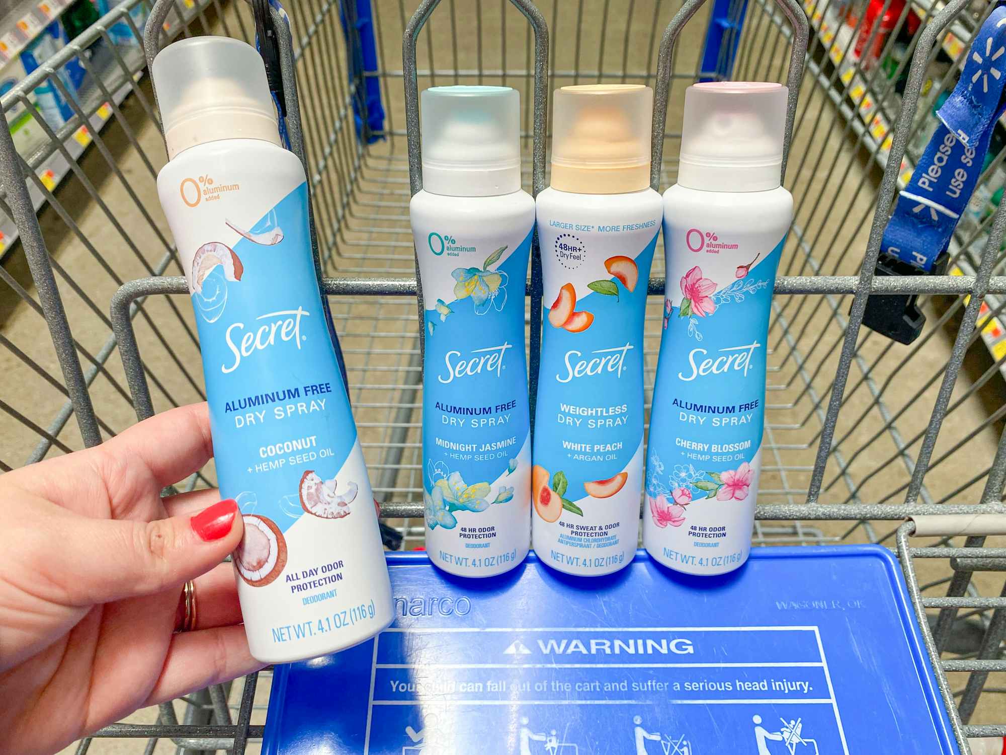 Some Secret Dry Spray deodorants in a Walmart shopping cart