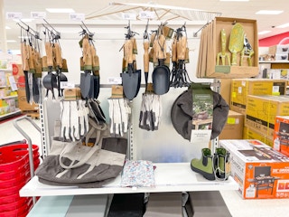 A variety of outdoor tools hanging from store racks and sitting on the store shelves.