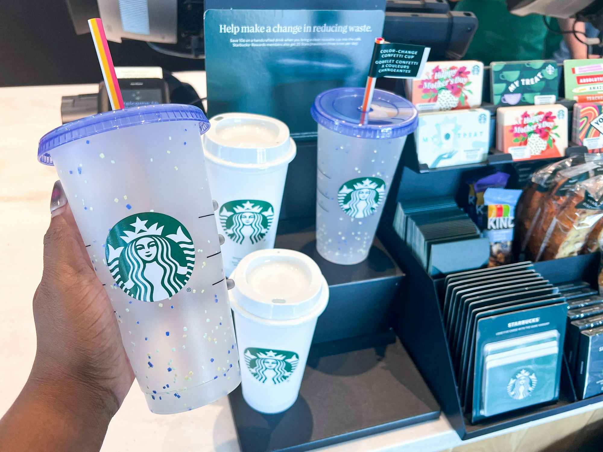 Someone holding a Starbucks Summer cup inside a Starbucks