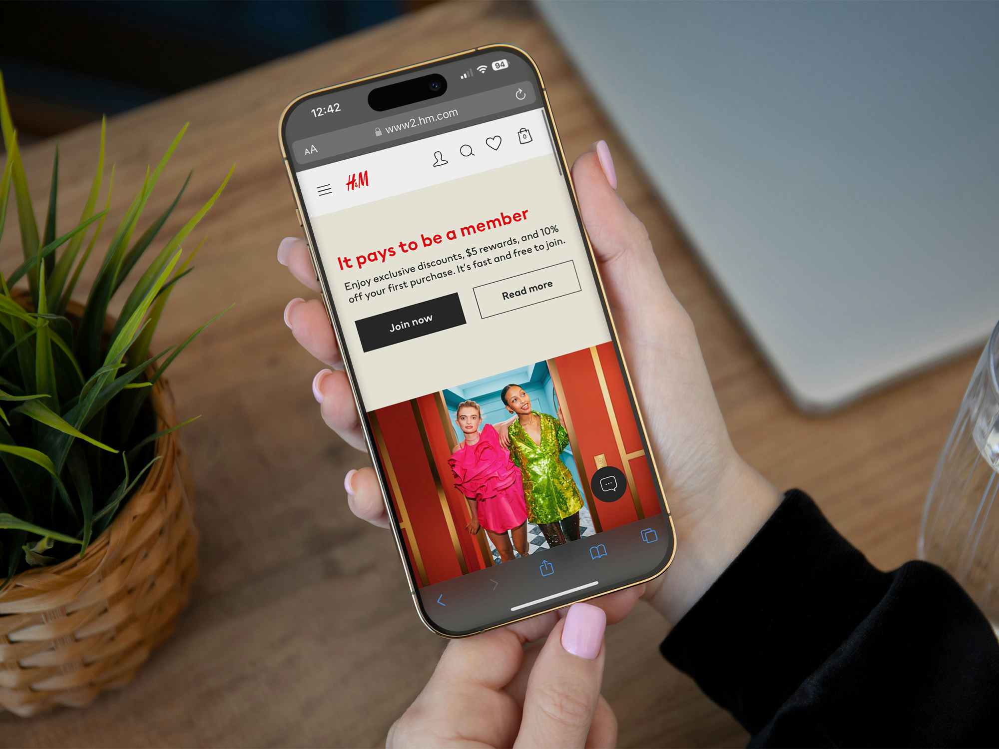 Someone holding a phone displaying the H&M website page about their rewards