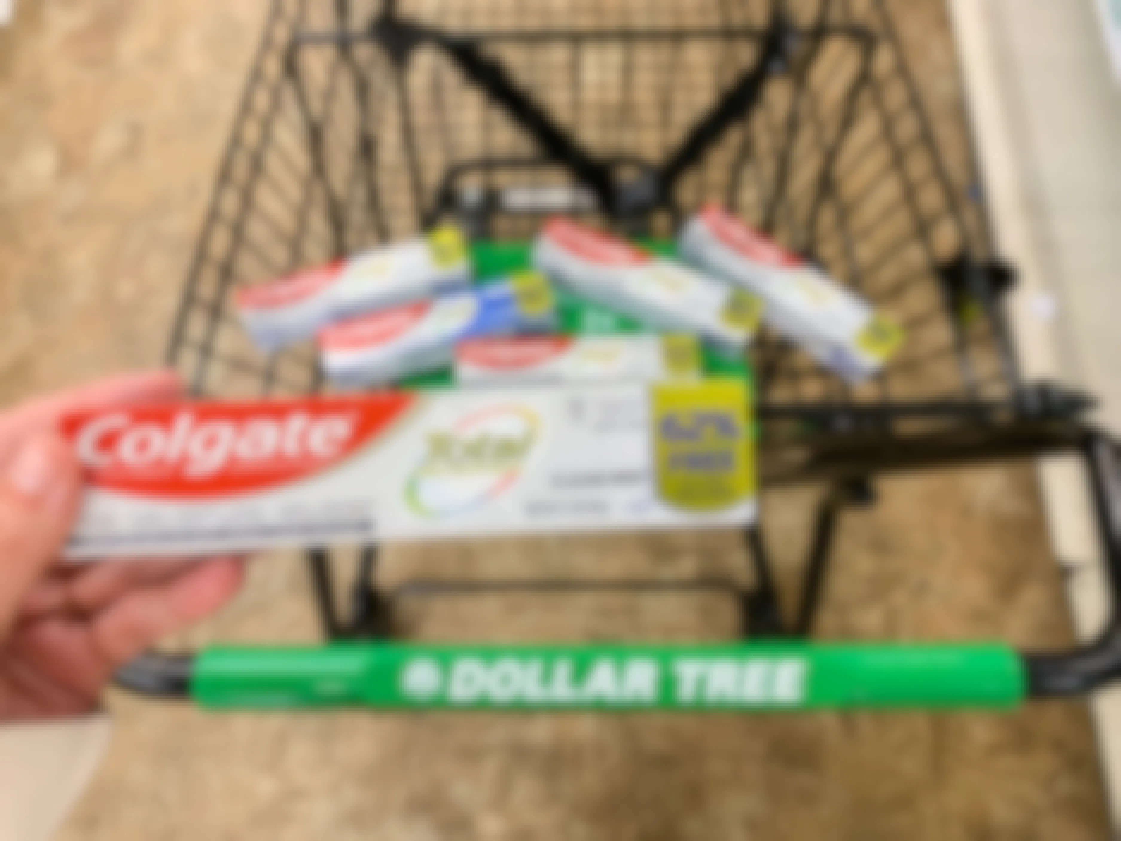 a person holding colgate toothpaste at the dollar store
