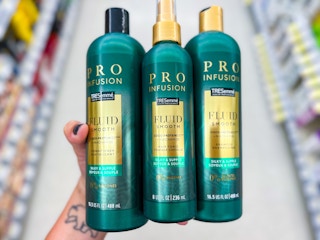 Someone holding three Tresemme products in a Rite Aid