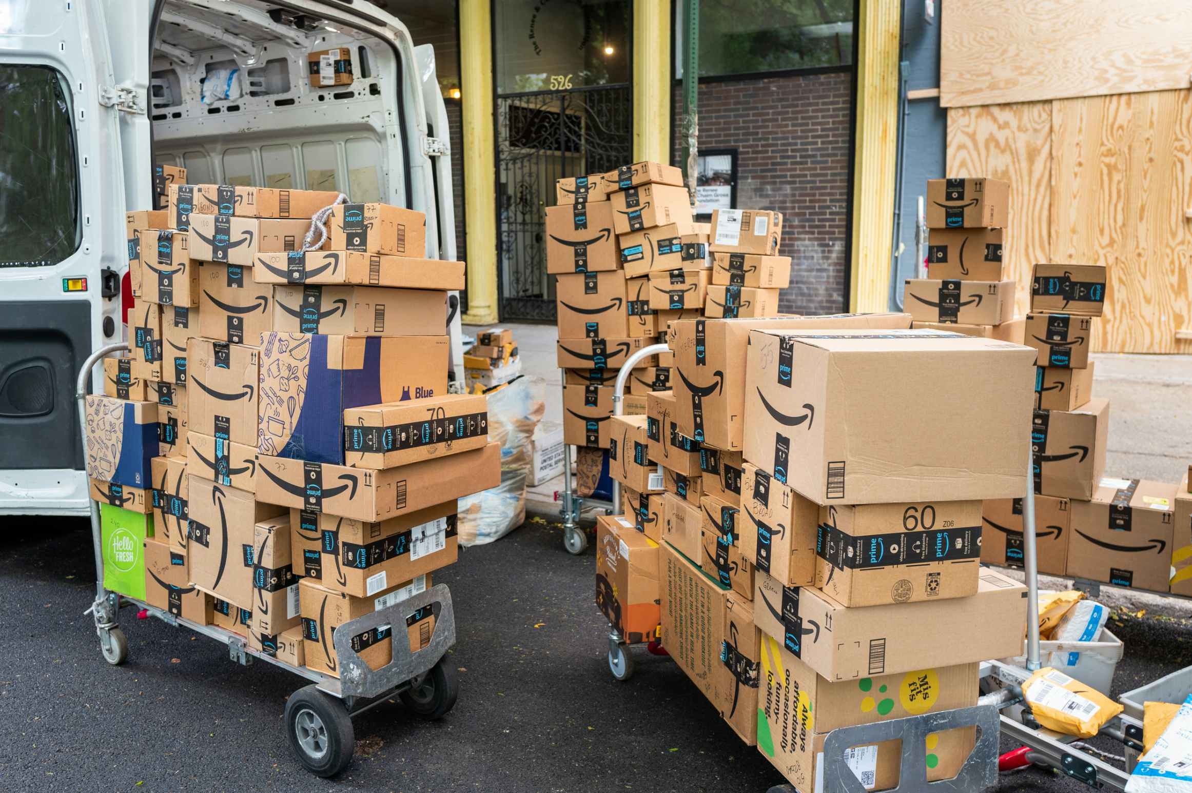 amazon boxes on dollies coming out of a delivery cargo van