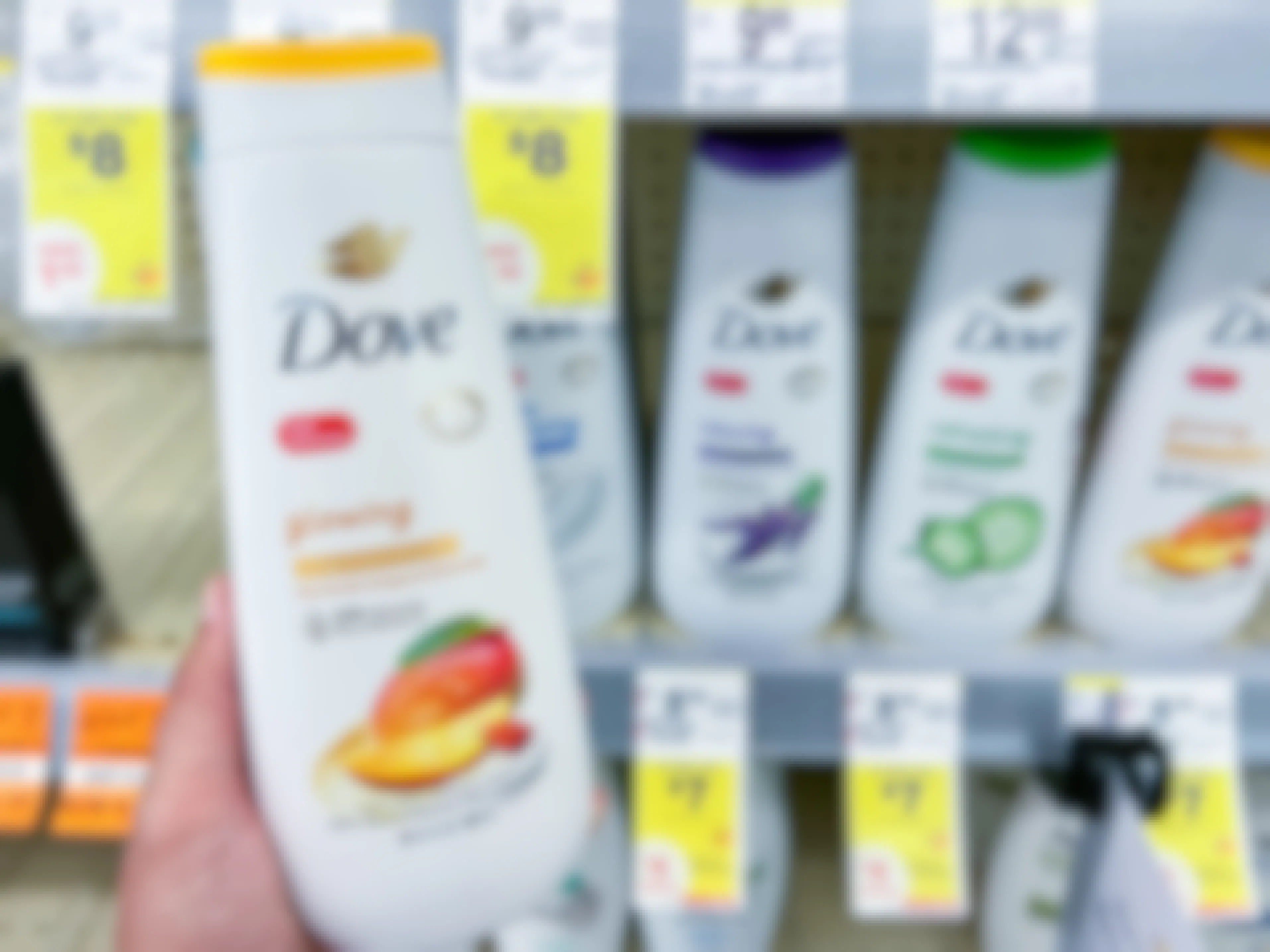 hand holding Dove body wash bottle in front of walgreens store sale tags