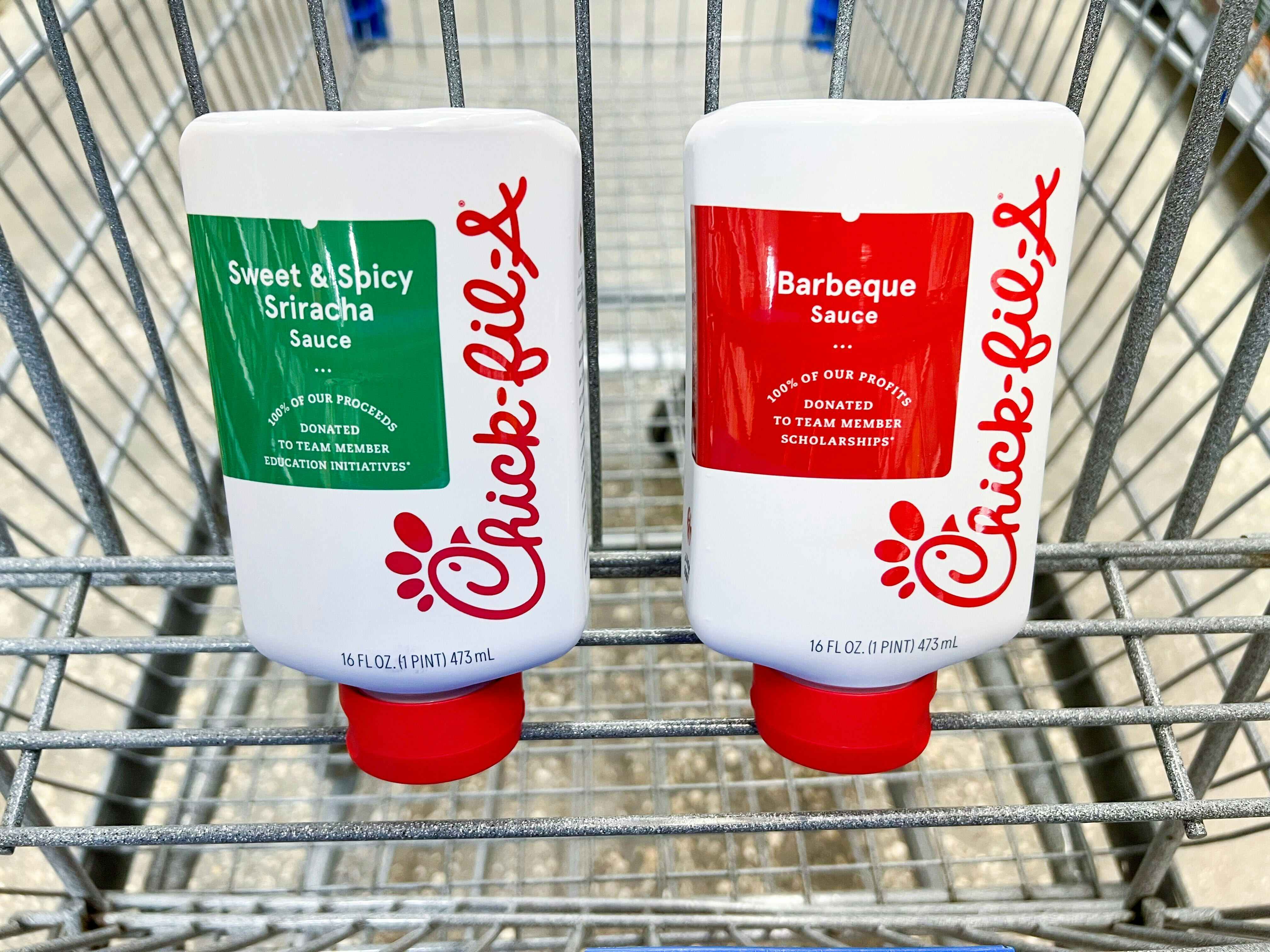 Bottles of Chick-fil-A barbeque and sweet & spicy sriracha sauce in a Walmart cart