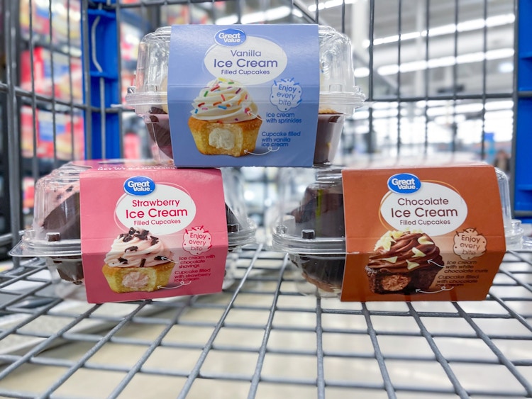 Three packs of Great Value Ice Cream Filled Cupcakes in a Walmart shopping cart: Vanilla, Chocolate, and Strawberry flavors