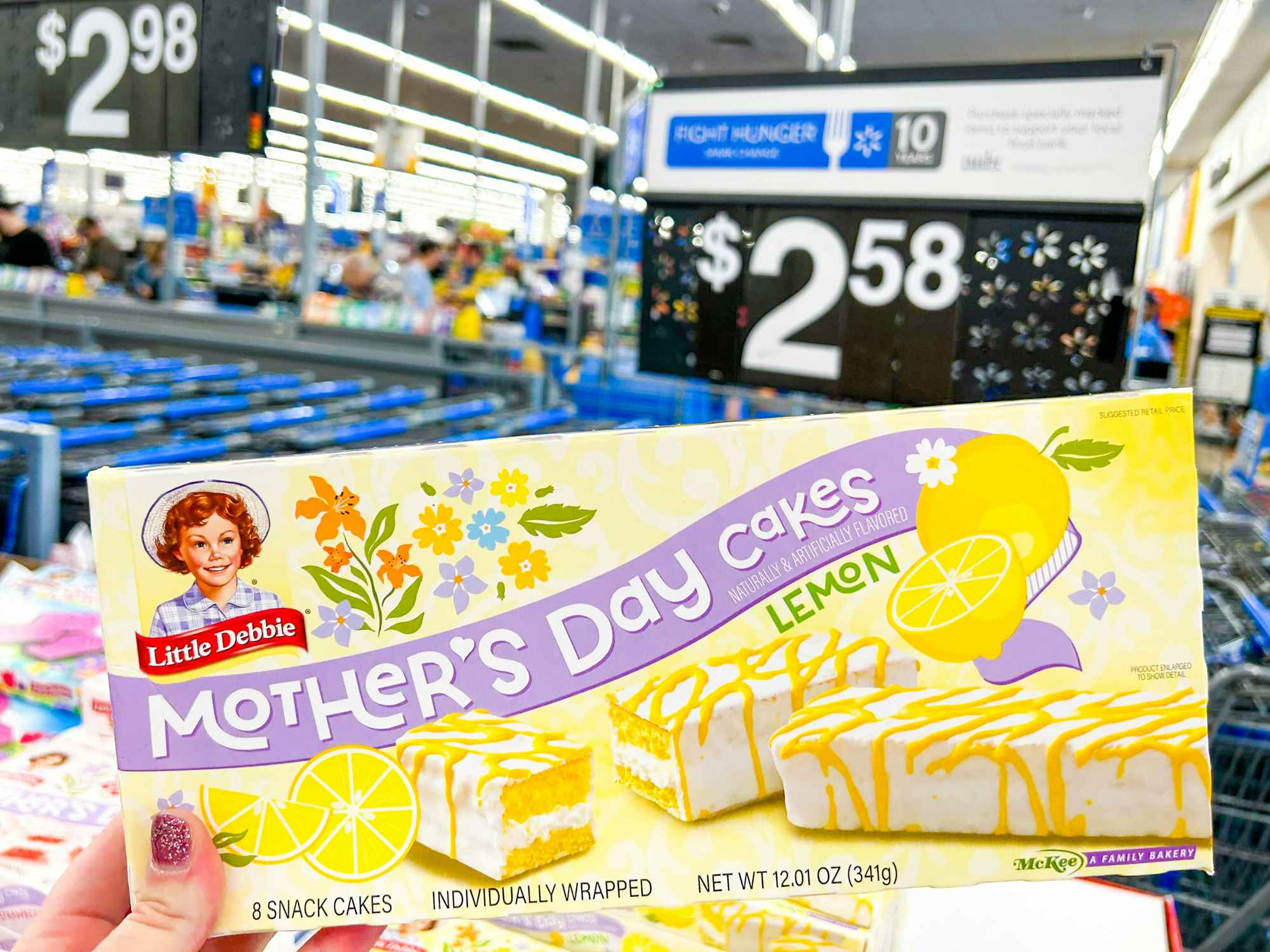 Someone holding a box of lemon Little Debbie Mother's Day Cakes in Walmart