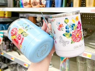 a woman holding up two floral spring mugs from the Pioneer Woman at Walmart
