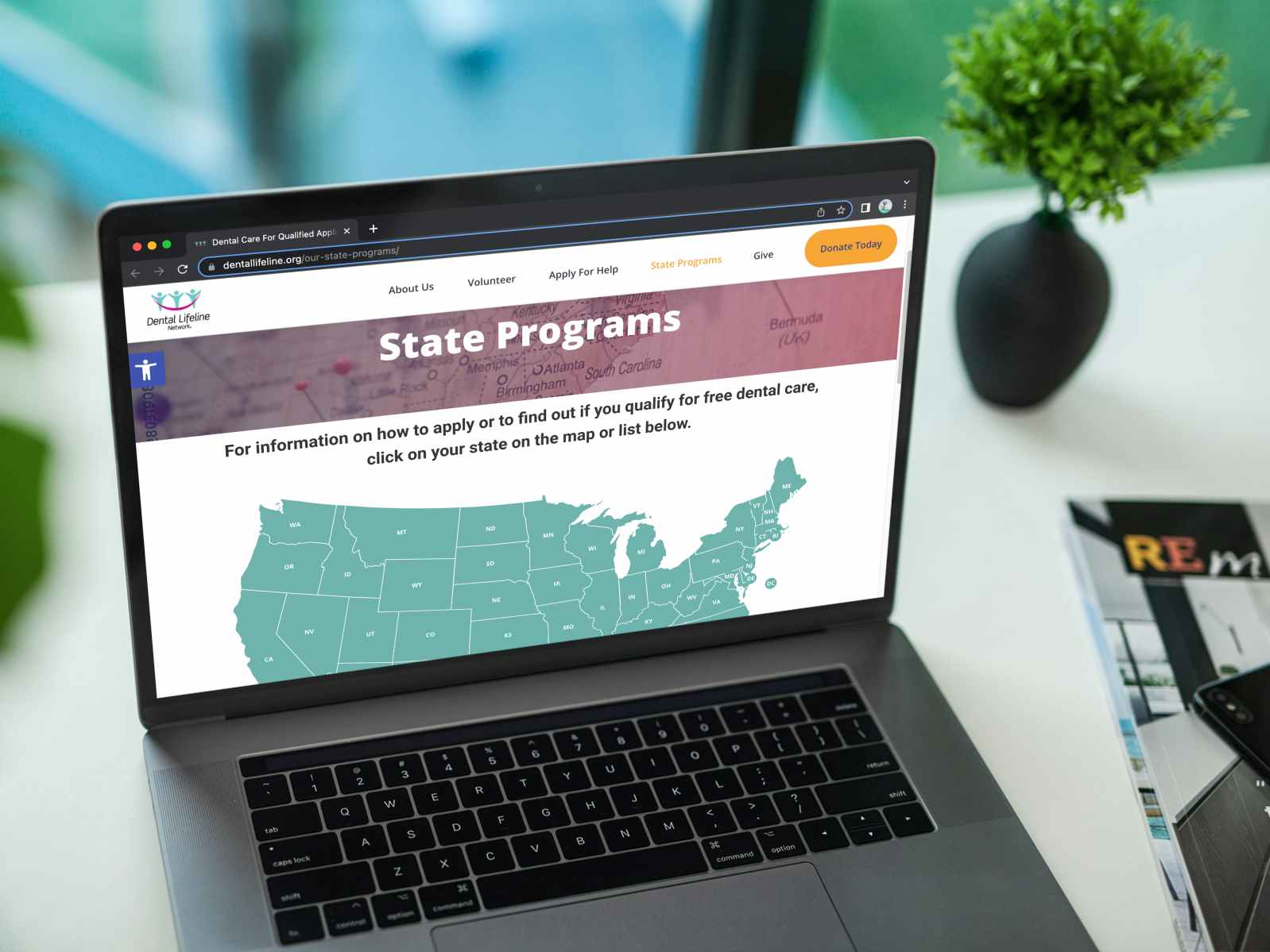 A laptop displaying the Dental Lifeline Network's website page for State Programs and a map