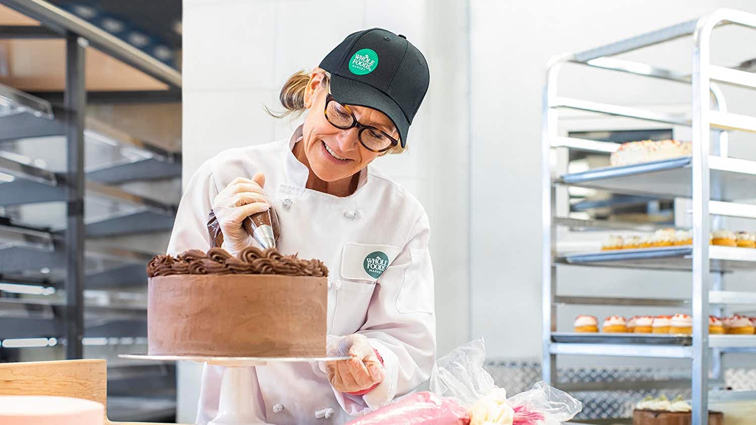 Cake decorator preparing a chocolate cake at Whole Foods
