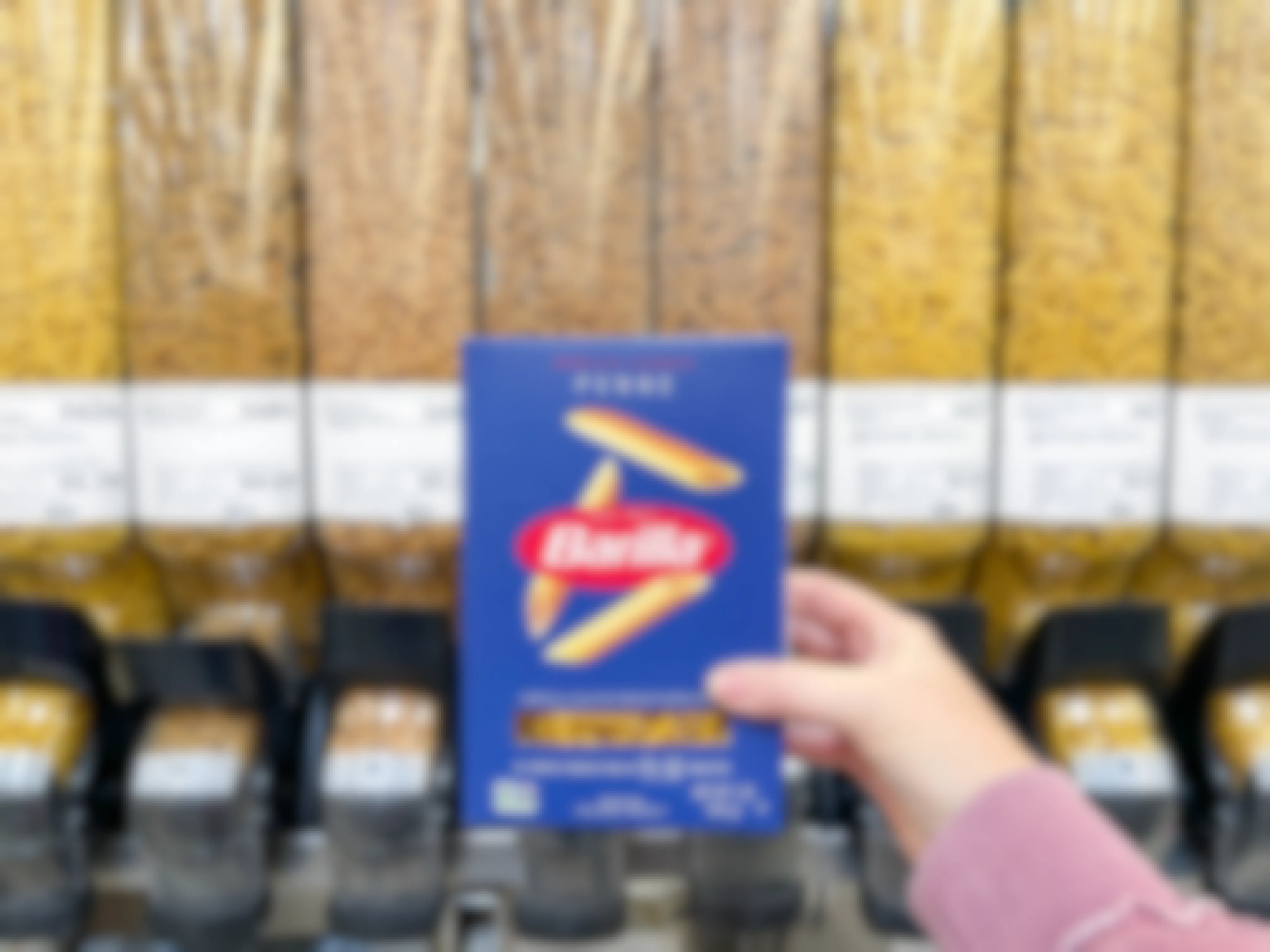 a package of pasta being held in front of winco bulk foods