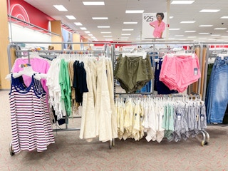 A variety of clothing hanging from a store rack.