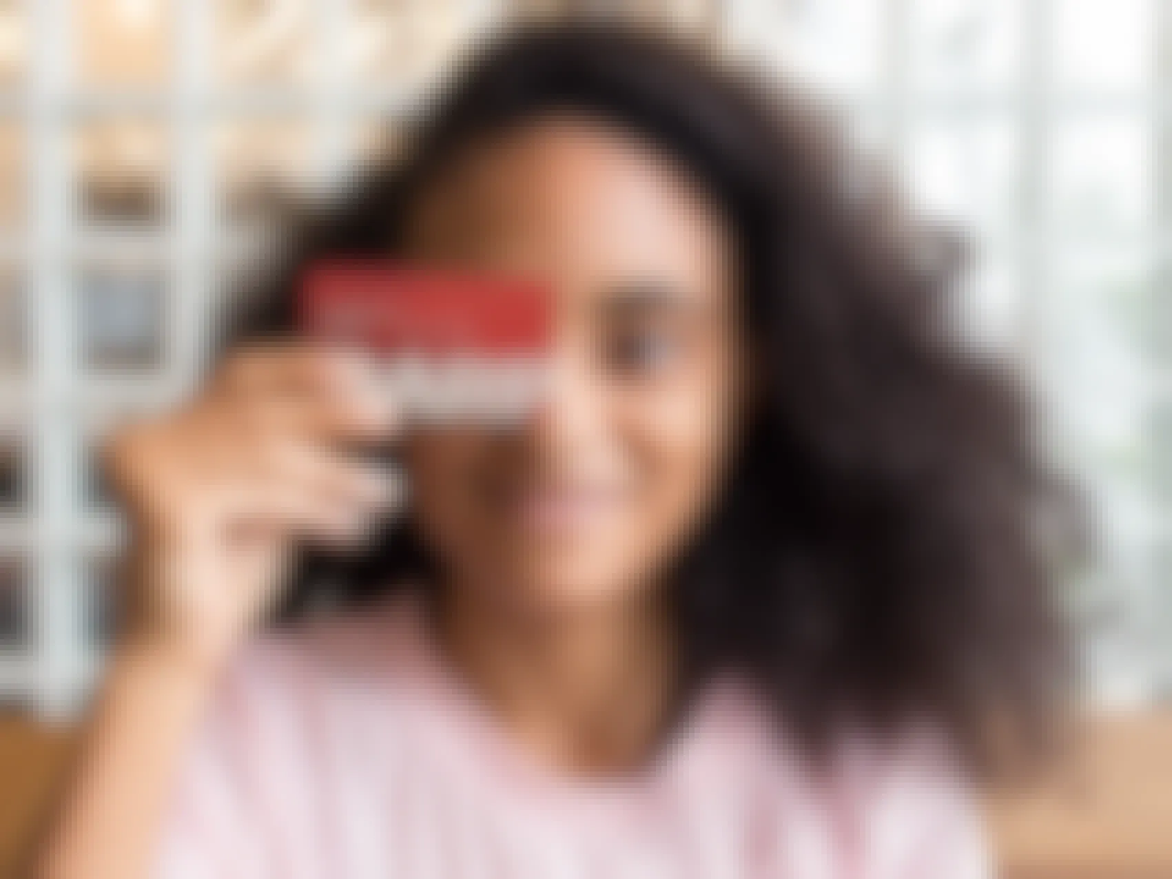 happy young person holding an aarp membership card
