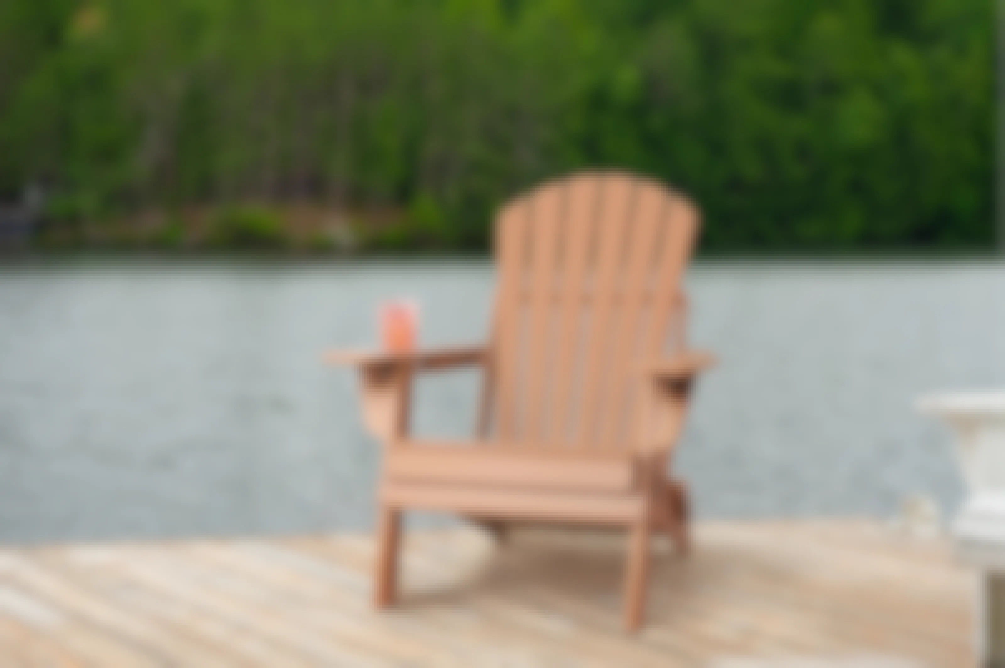 Brown Adirondack chair on a wooden pier by the water