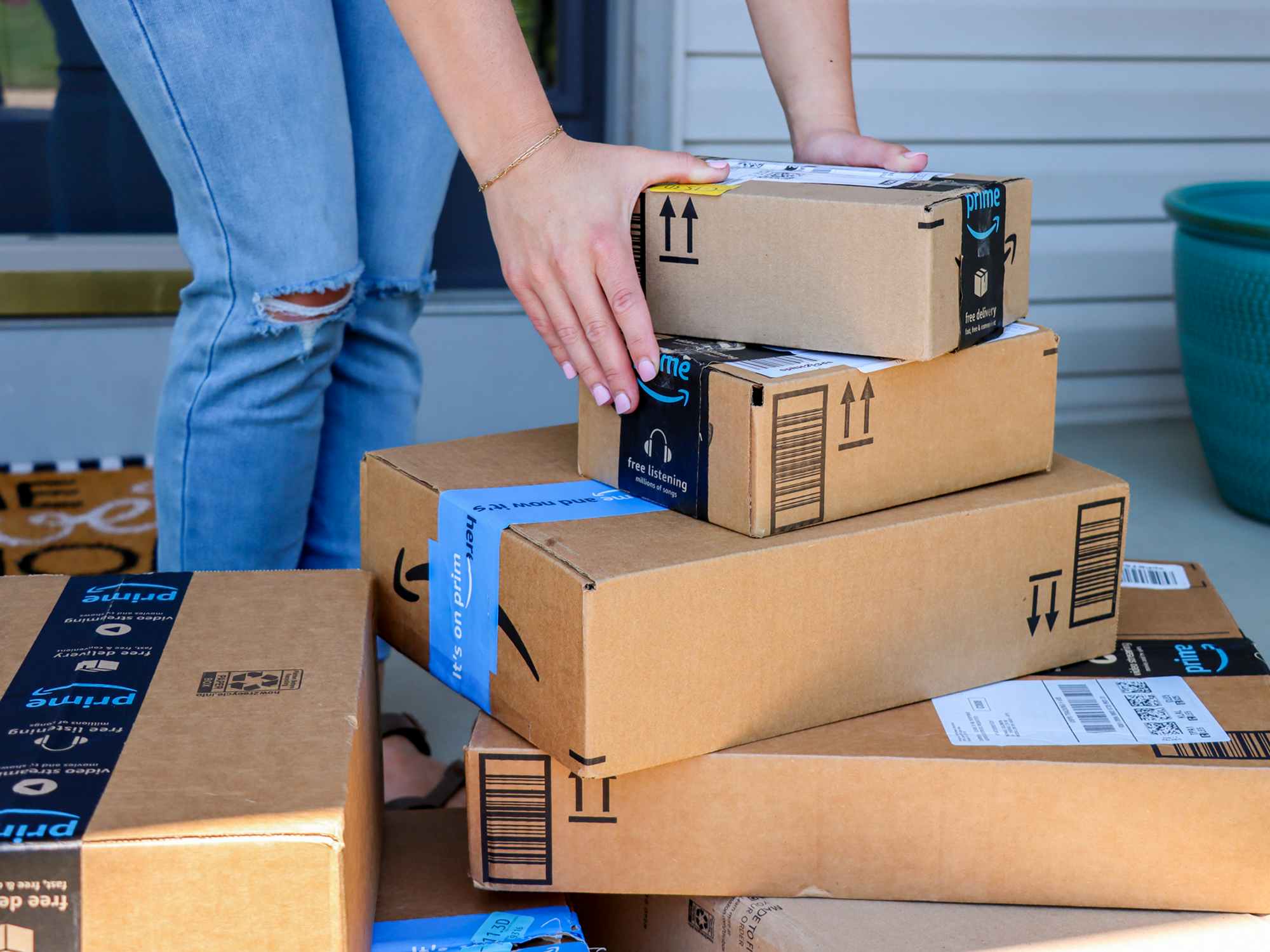 a person reaching for a stack of amazon boxes