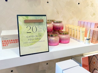 A sign for a sale at Anthropologie for 20% off Capri candles