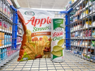An Apple Straws bag and a Veggie Chips can sitting in a store cart.