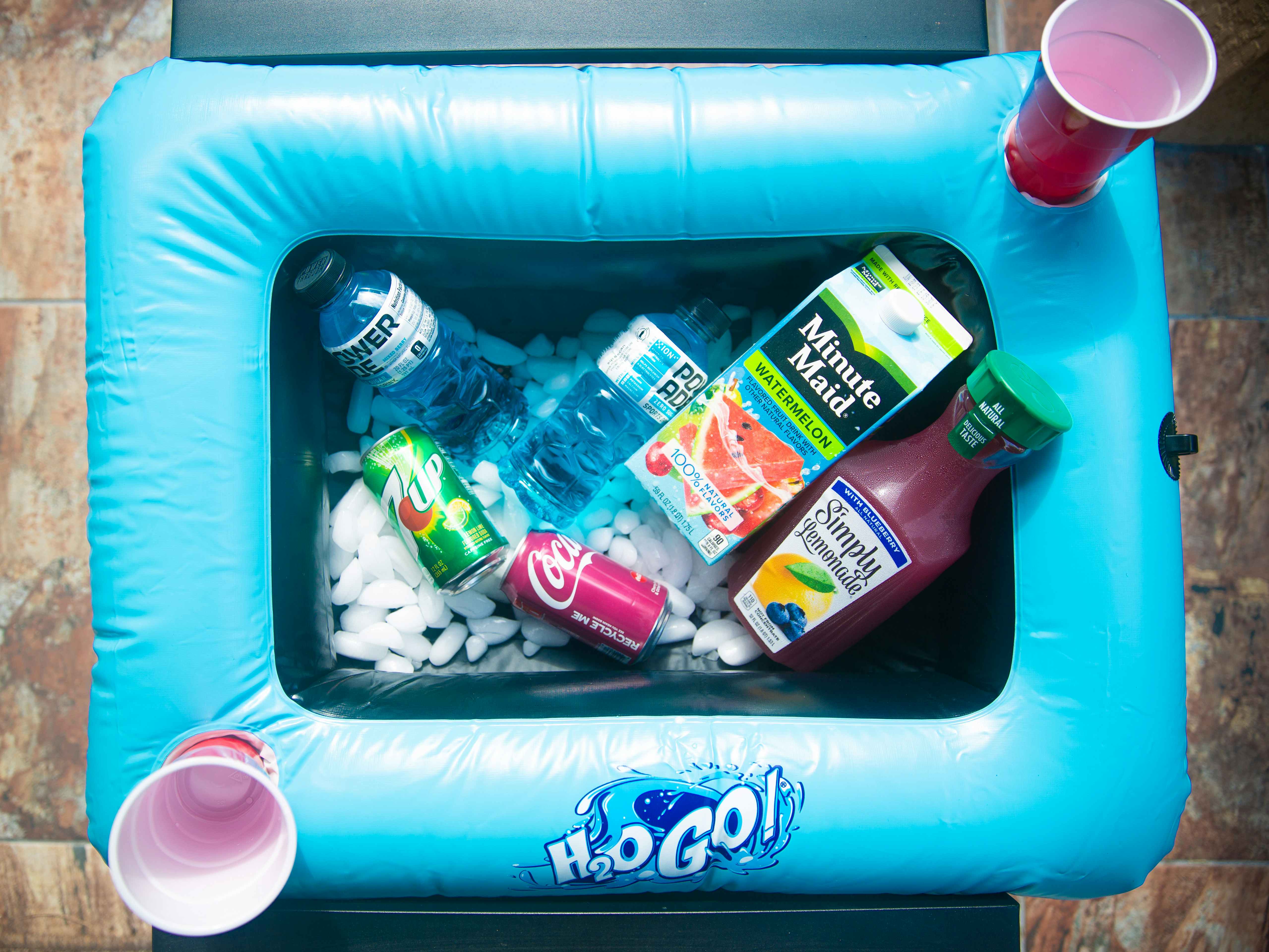 Blue pool raft with assorted drinks with two red cups