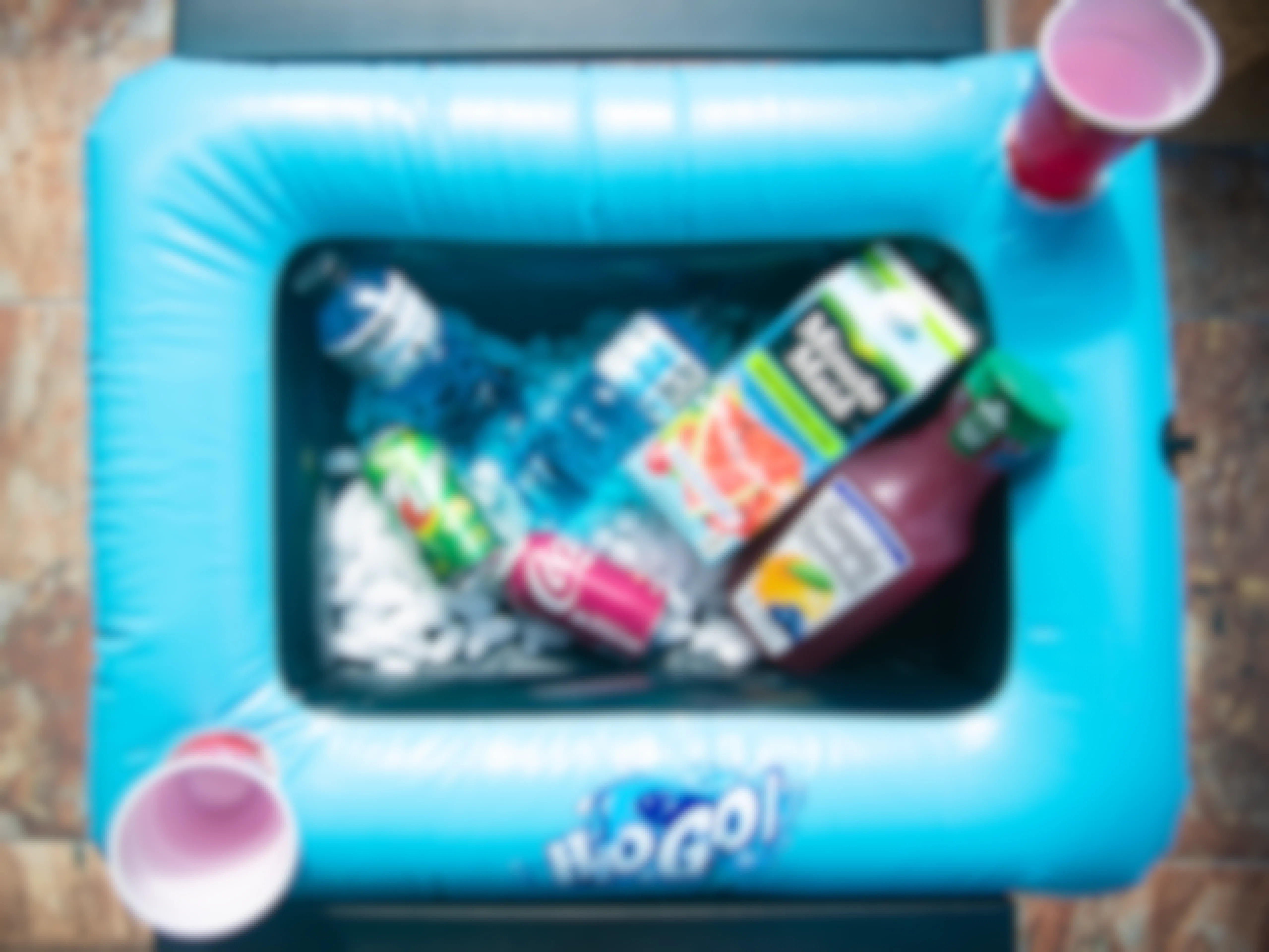 Blue pool raft with assorted drinks with two red cups