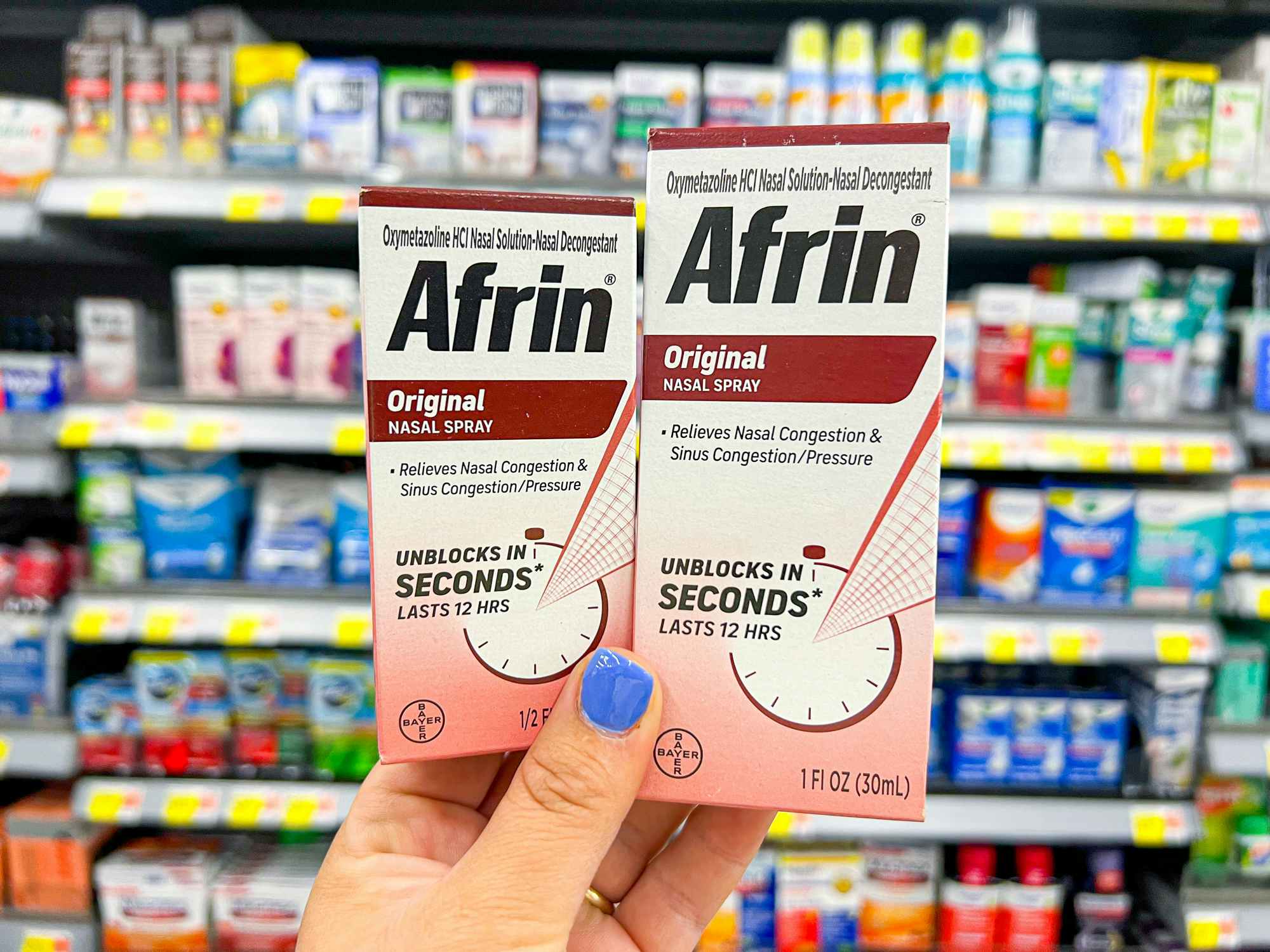 Someone holding up boxes of Afrin in a store