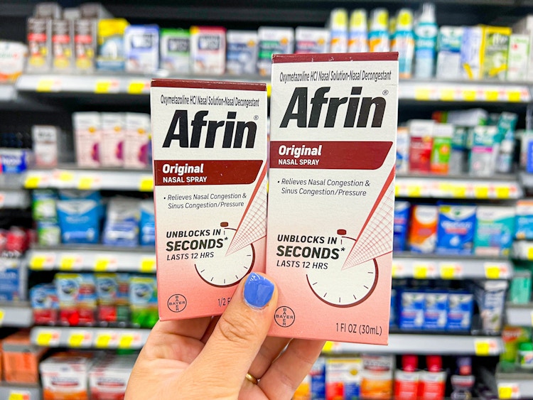 Someone holding up boxes of Afrin in a store