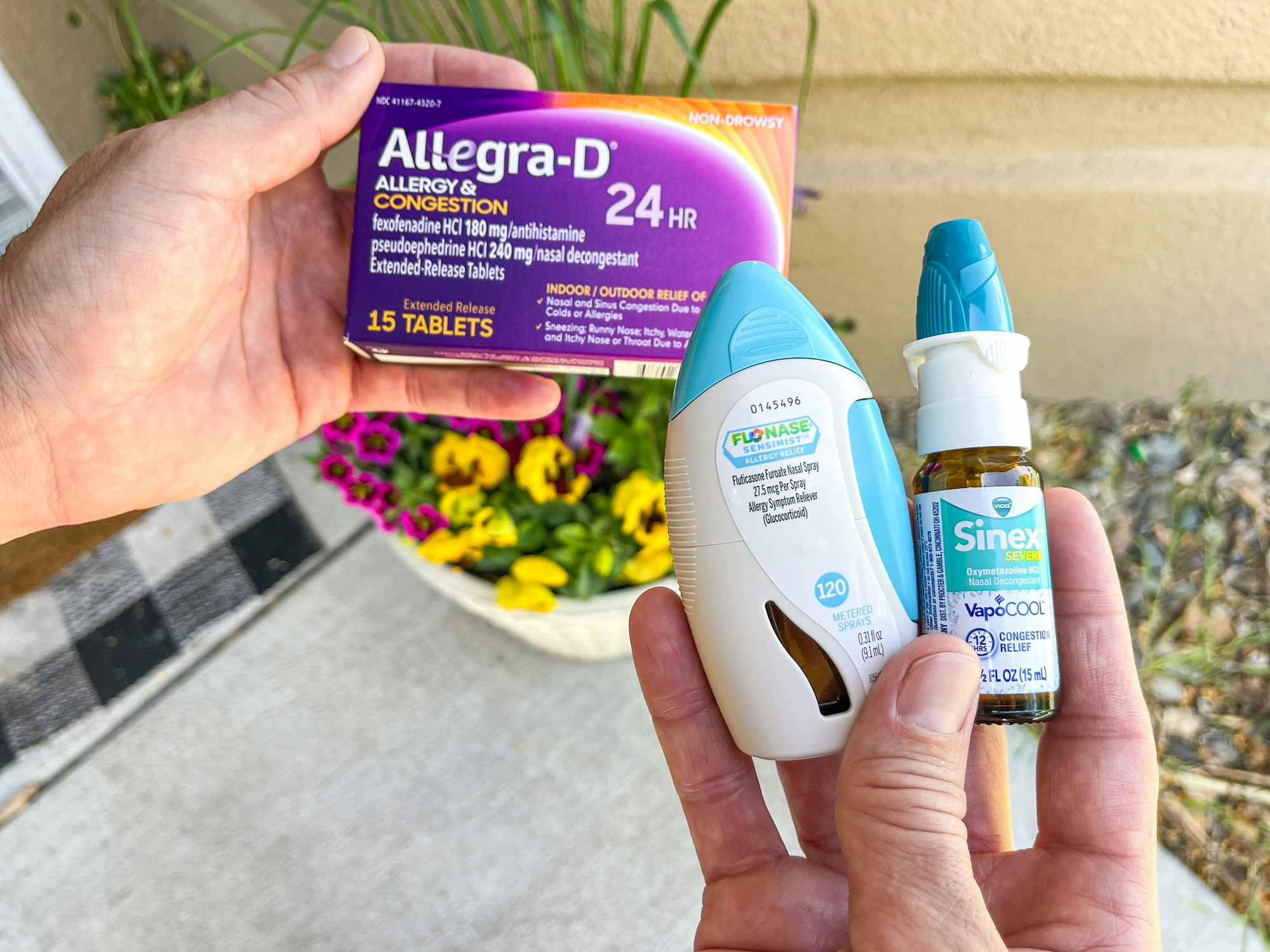 Someone holding different kinds of allergy medications at home