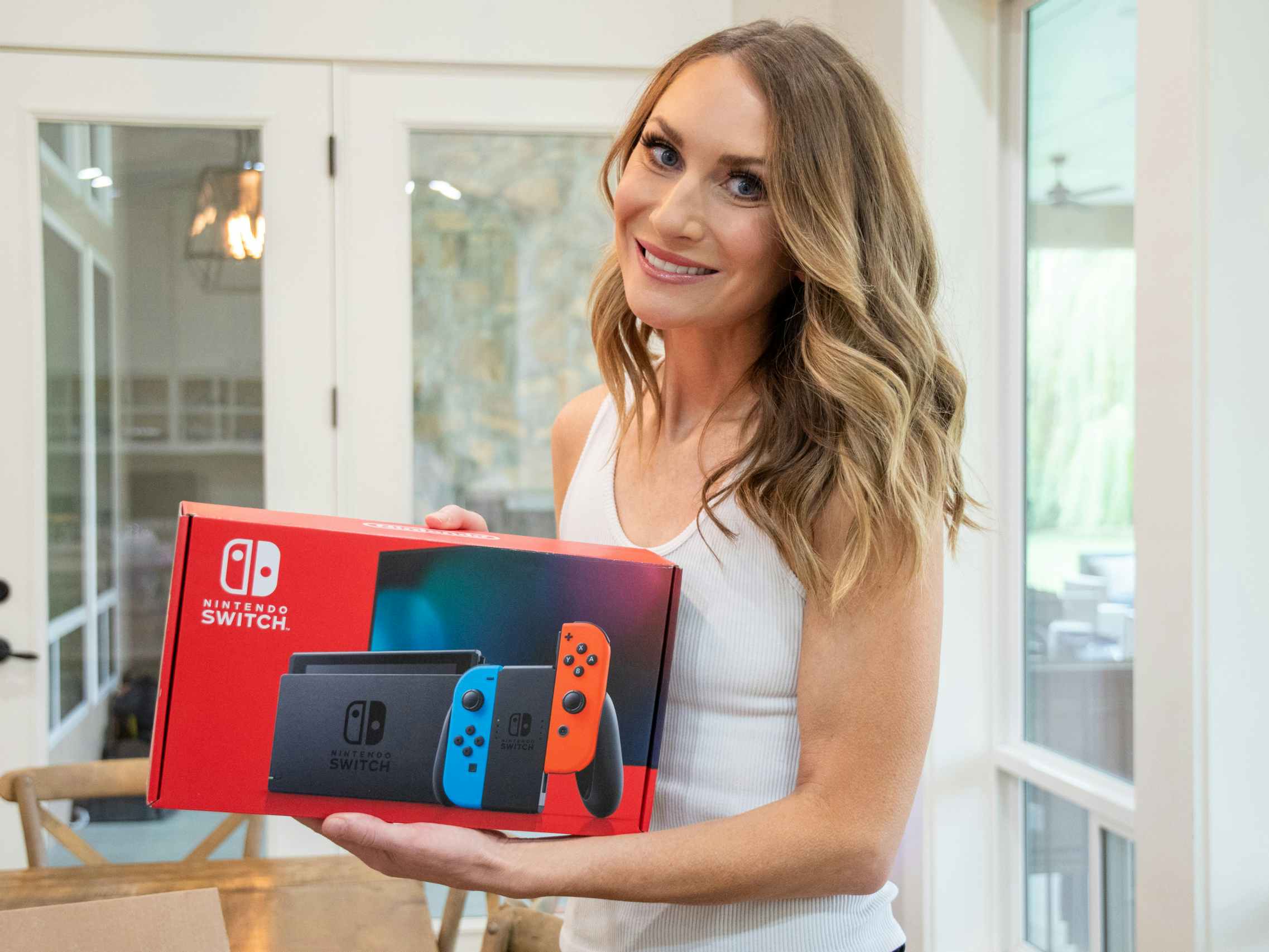 a person holding up a nintendo switch