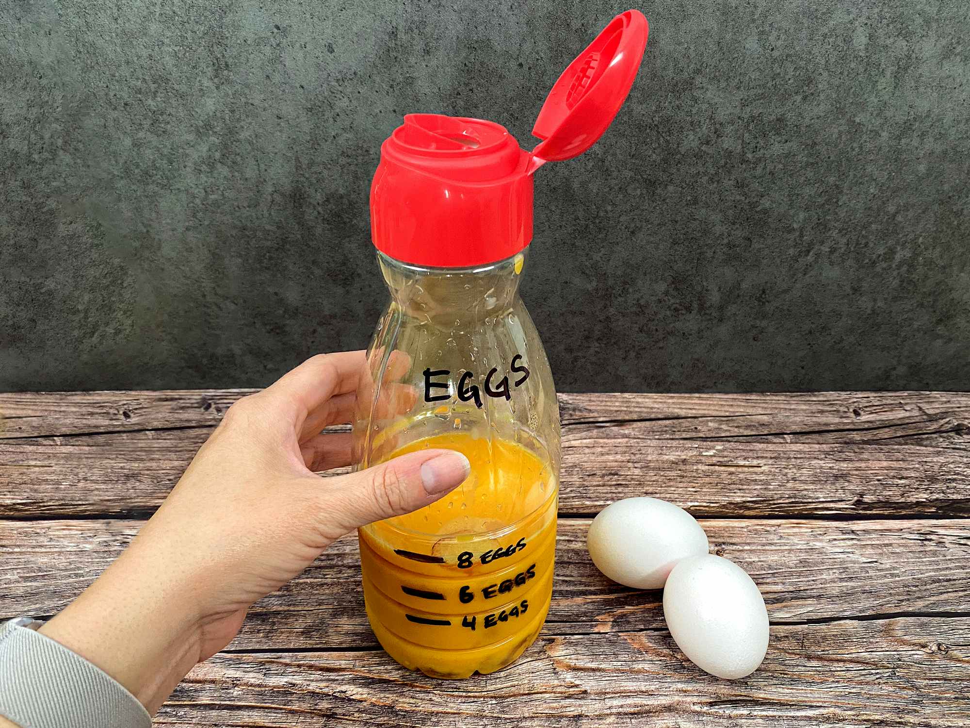 person grabbing a coffee creamer bottle filled with eggs for camping