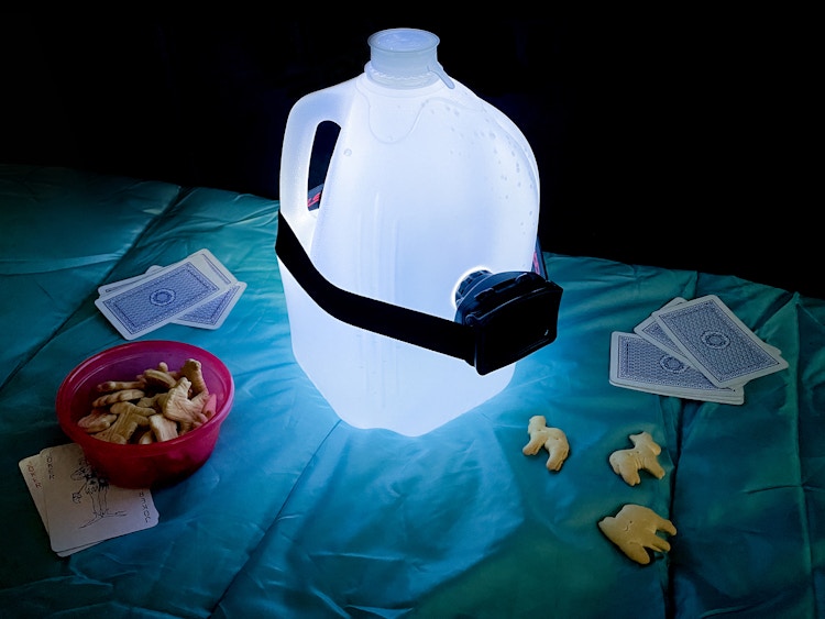 a gallon jug of water with a headlamp to make a diy lantern for camping